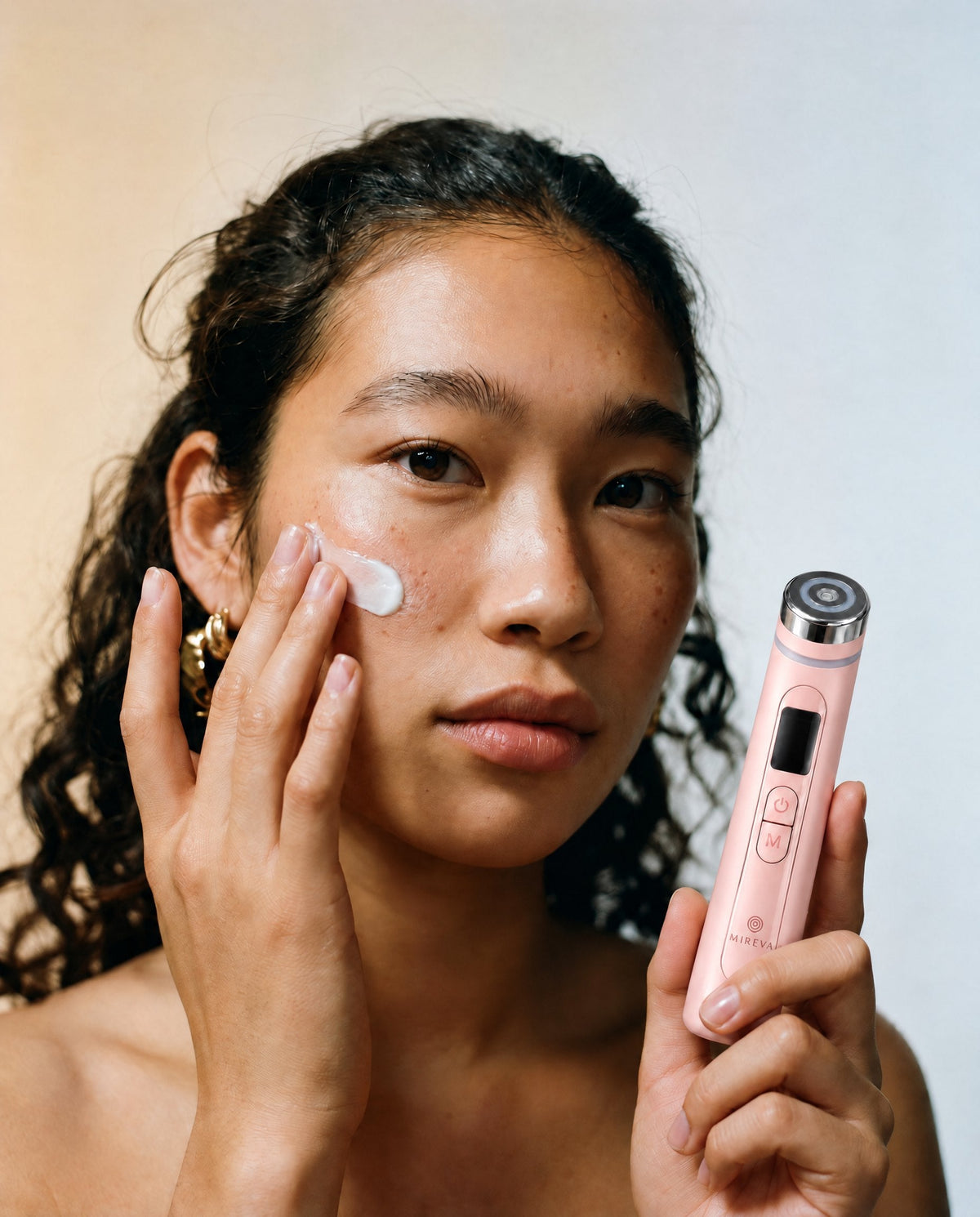 Model applying serum, holding the Mireva Derma Booster Wand